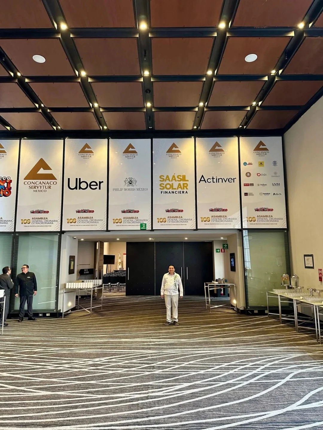El M. en C. Juan José Aguayo Puc frente a los paneles de patrocinadores de la 109 Asamblea General de la CONCANACO SERVYTUR, con Saásil Solar Financiera junto a Uber, Philip Morris México y Actinver