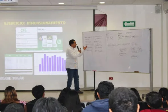 El Mtro. Aguayo explica el ejercicio de dimensionamiento junto al pizarrón